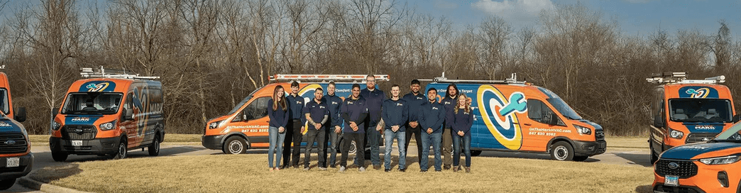 The On the Mark Heating & Air team beside their service vans