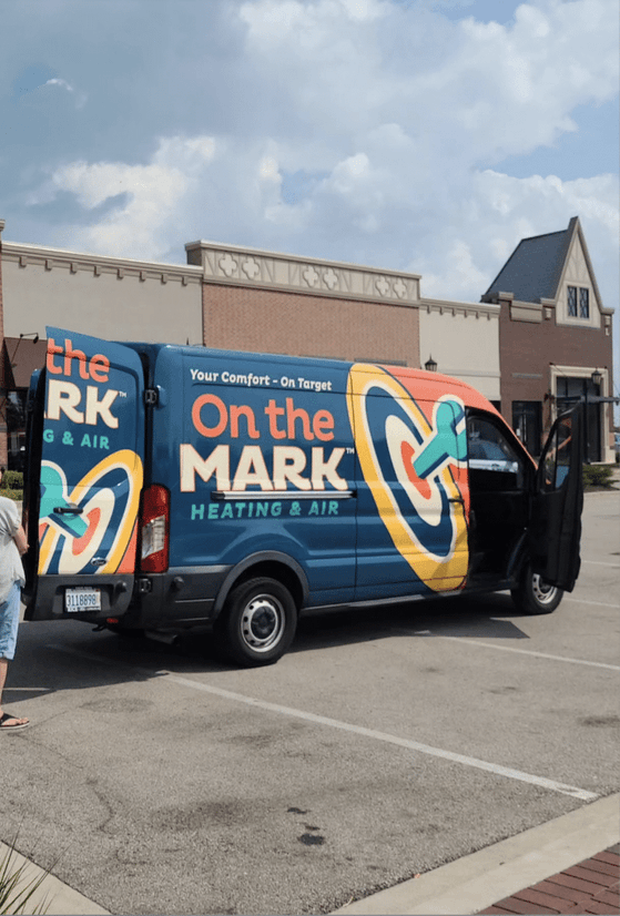 An On the Mark Heating & Air service van parked outside a customer's home