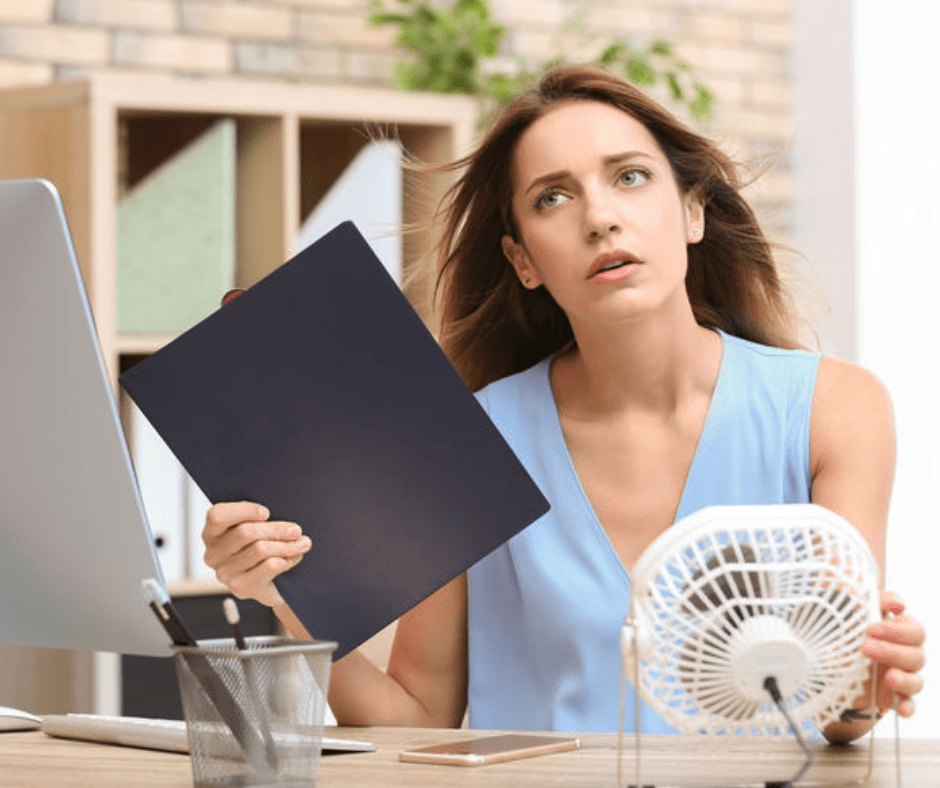 woman fanning herself because upstairs hotter than downstairs