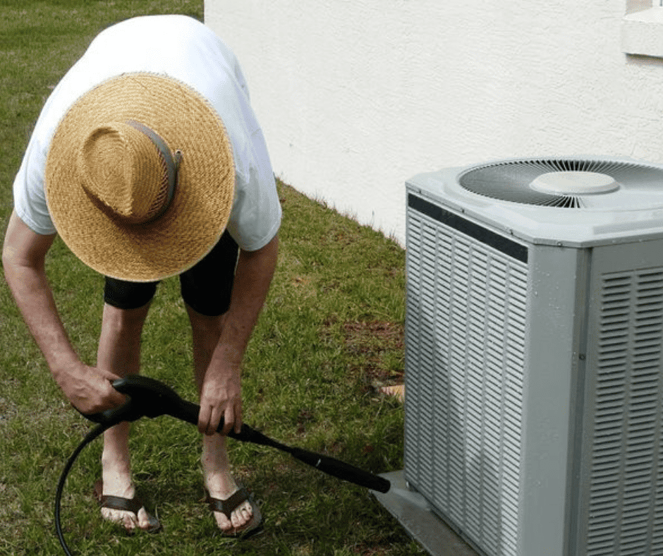 person cleaning outdoor ac unit in schaumburg il